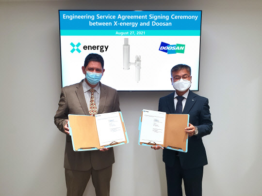 미국 매릴랜드주(Maryland) 록빌시(Rockville) X-energy 본사에서 마틴 반 스테든(Martin Van Staden) 부사장과 김종두(오른쪽) 두산중공업 상무가 계약 서명식을 하는 모습. <두산중공업 제공>